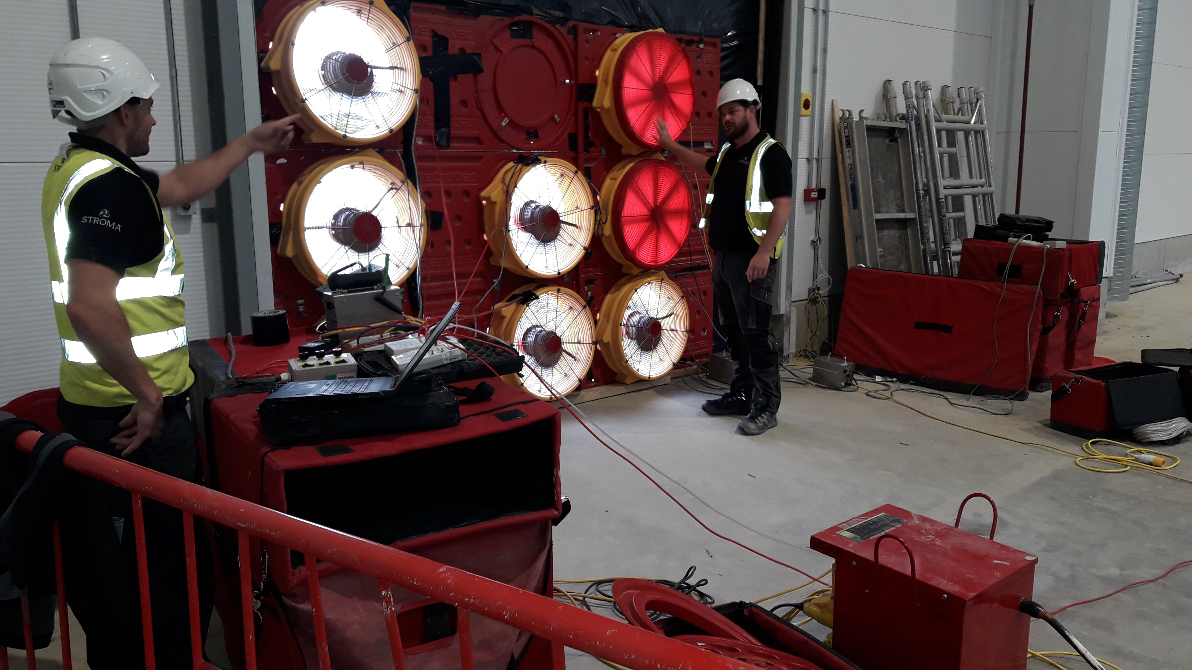 two men testing air tightness in a building