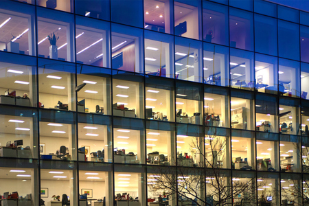 windows externally of a building with various lit offices